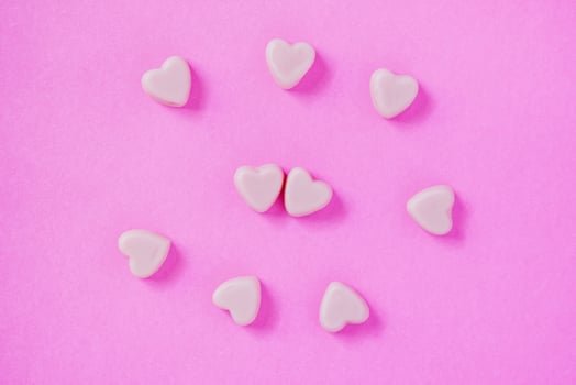valentine candy hearts shape on pink background photo