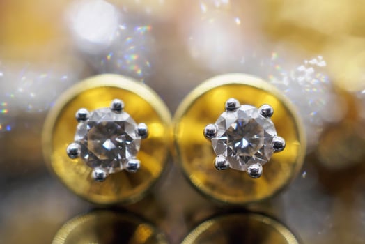 Luxury gold Jewelry diamond earrings with reflection on black background photo