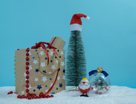 A paper bag with gifts next to the Christmas tree. Christmas toys in the snow. Merry Christmas. photo