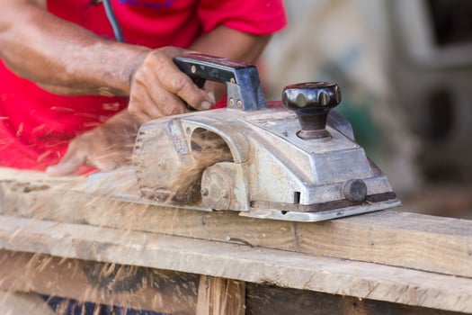 Carpenter working with electric planer photo