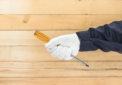 Hand in glove holding screwdriver photo
