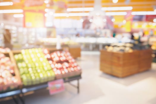 Supermarket with fresh fruits and vegetable on shelves in store blurred background photo