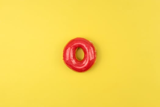 A tasty glazed donut lies on a yellow background photo