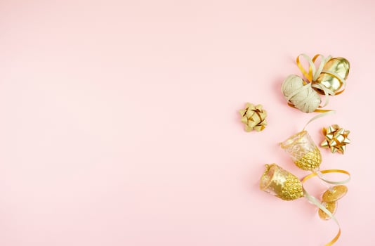 a flat lay of golden bows and accessories for holidays lying on a pink background photo