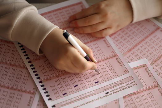 Filling out a lottery ticket. A young woman plays the lottery and dreams of winning the jackpot. Female hand marking number on red lottery ticket photo