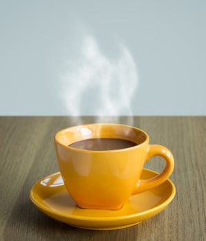 steaming coffee cup on table photo