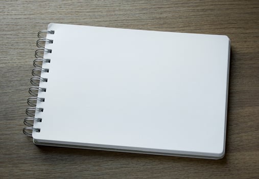 blank spiral notebook on dark wood background photo