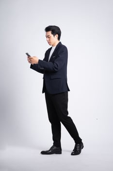 Young business man wearing a suit posing on a white background photo