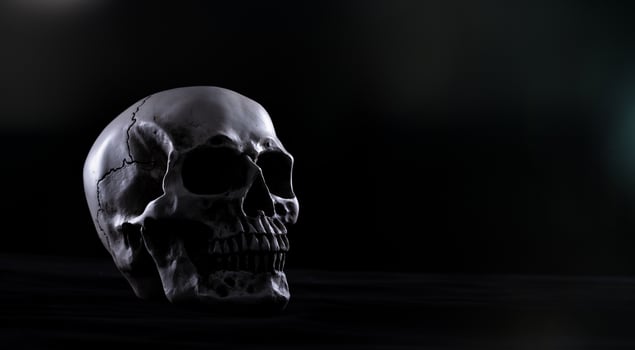 Halloween human skull on an old wooden table over black background. Shape of skull bone for Death head on halloween festival which show horror evil tooth fear and scary, copy space photo