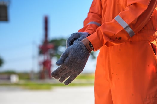 Wearing Construction Safety Gloves Closeup Photo. man wearing safety gloves in oil field site photo