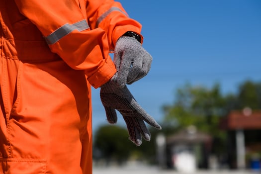 Wearing Construction Safety Gloves Closeup Photo. man wearing safety gloves in oil field site photo