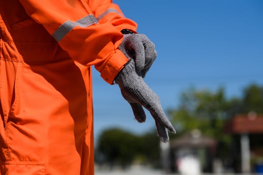 Wearing Construction Safety Gloves Closeup Photo. man wearing safety gloves in oil field site photo