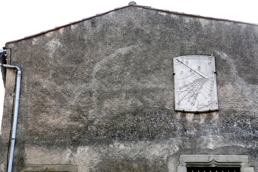 wall of medieval house with sun-clock photo