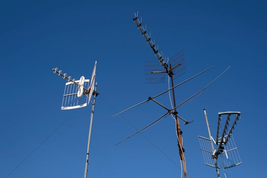 Three antennas against a blue sky photo