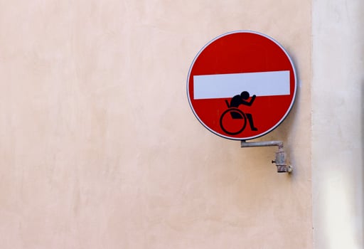 No Entry street sign with a wheelchair sticker on it. photo