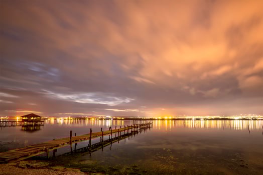 Beautiful night reflections in the sea from the port and moving clouds photo