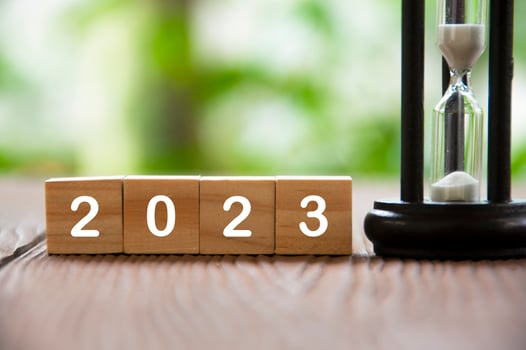 Year 2023 text on wooden blocks with minute glass and blurred nature background. New year concept 2023 photo
