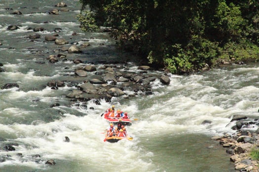 Photo of rafting activities carried out by a group of people on a rocky river with strong currents