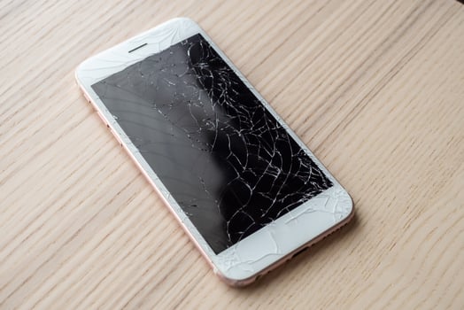 broken glass of mobile phone screen on wooden background photo