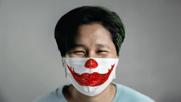 Halloween in Covid-19 Situation Concept. Happy Person Wearing a Surgical Mask.  Red Smiling Lipstick Painted on Mask photo