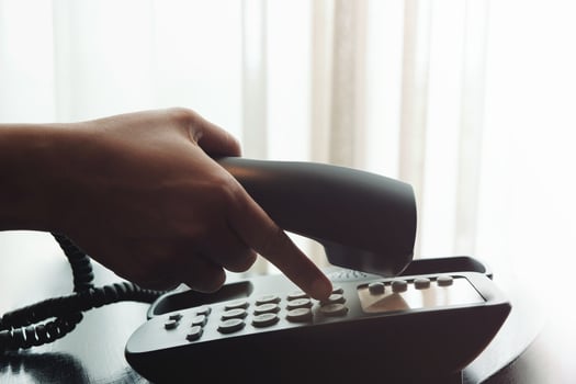 Close-up of Woman's Hand using a Telephone in House or Hotel near the Window photo