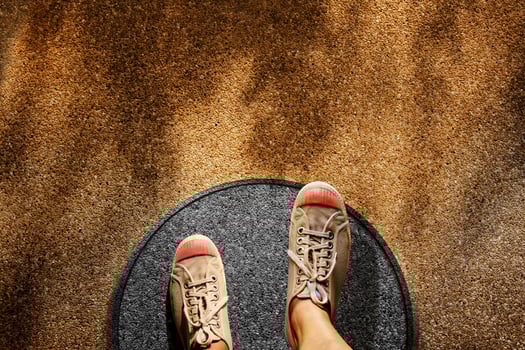 Comfort Zone Concept. Male on Sneaker Shoes Steps over Circle Line to Outside Bound, Top View, Grunge Dirty Concrete Floor with Sunlight as background photo