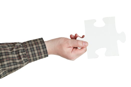 male hand holding big white paper puzzle piece photo
