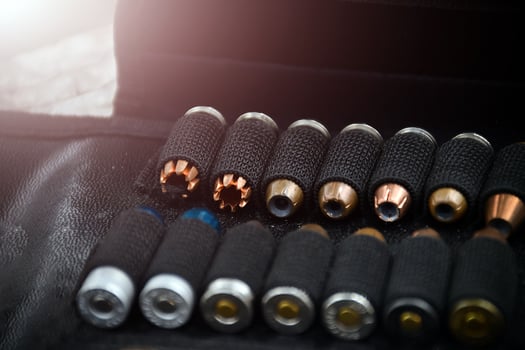 9mm pistol bullets kept in black leather pocket, selective focus on bullet. photo