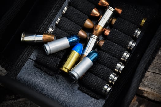 9mm pistol bullets kept in black leather pocket, selective focus on bullet. photo