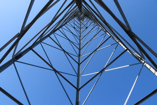 Electric antenna and communication transmitter tower in a northern european landscape against a blue sky photo