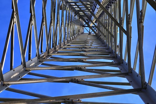 Electric antenna and communication transmitter tower in a northern european landscape against a blue sky photo