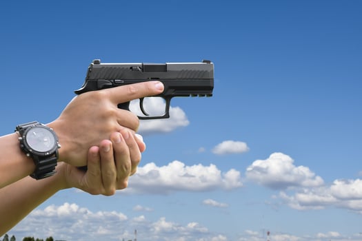 Pistol holding in hands of gunman at the shooting club, soft and selective focus on pistol, concept for shooting sport, bodyguard, security training, mafias, gangsters and self protections. photo