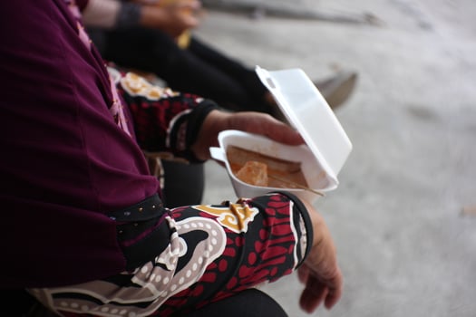 someone is carrying a white box of food photo