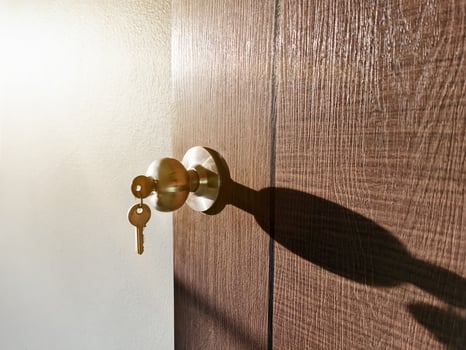 House key with home keyring in keyhole on wood door photo