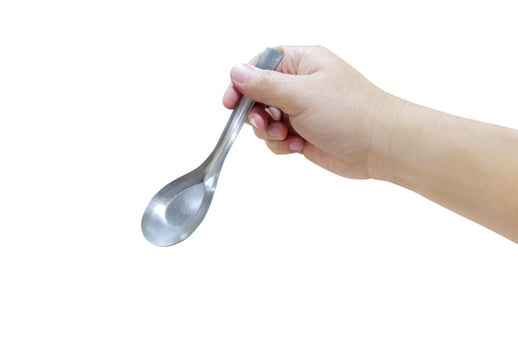 Hand holding a silver plated spoon isolated on white background. photo