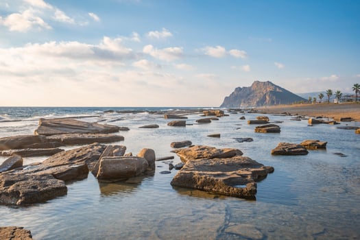 Long exposure photography of waves and pebbles on Beach in the sunset photo