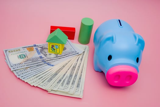 Hand of the kids take a wood block with small  house models on top of block.Concept of saving money for future , investment property and saving money to buy a house. On blur background. photo