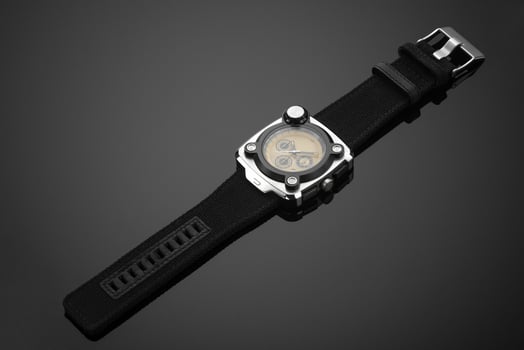 A close-up shot of a watch placed on a reflecting surface. photo