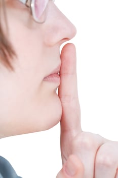 forefinger near lips - silence hand gesture photo