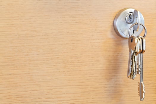 bunch of home keys in lock of wooden door photo