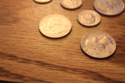 Quarters and Dime coins are the currency of America. Spread them on the wooden floor. photo