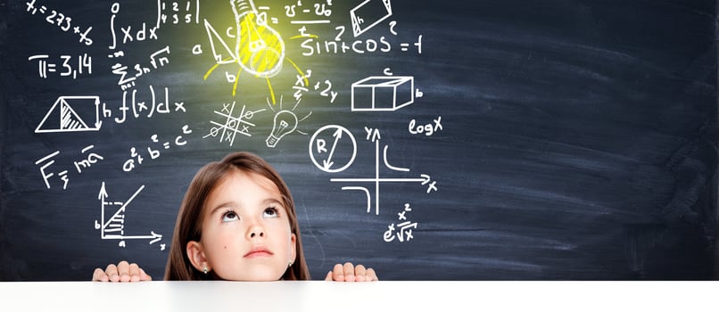 Young cute girl at chalkboard with light bulb over head photo