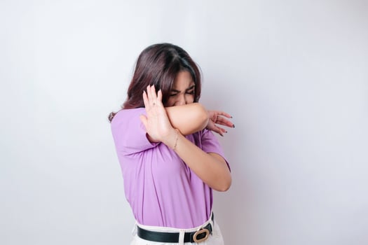 Young Asian woman isolated on white background, looks depressed, face covered by fingers frightened and nervous. photo
