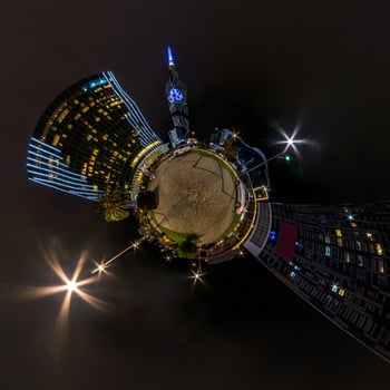 tiny planet in night sky in city center near modern skyscrapers or office buildings. Transformation of spherical 360 panorama in abstract aerial view. photo