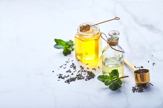 Bottle of essential oil of mint and green leaves and jar of honey. Natural organic ingredients for cosmetics, skin care, body care. Beauty care concept photo