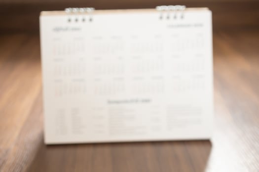 calendar page on wood floor blurred for background photo
