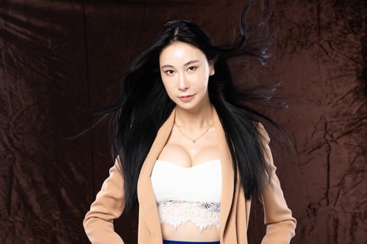 Haft body portrait of beautiful transgender 20s asian woman express feeling smiling confidently on brown background. Business Female smart look blazer has wind blow throw her hair in air, copy space photo