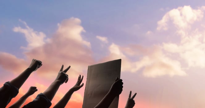 Protest, Mob, Expression and Strike Concept.  Silhouette of People Raise Up Hands into the Sky. the Leader Holding a Corrugated Paper. photo