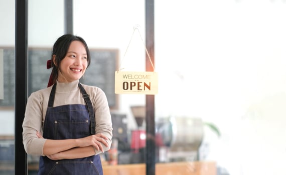 Startup successful small business owner sme beauty girl stand with tablet smartphone in coffee shop restaurant. Portrait of asian tan woman barista cafe owner. SME entrepreneur seller business concept photo