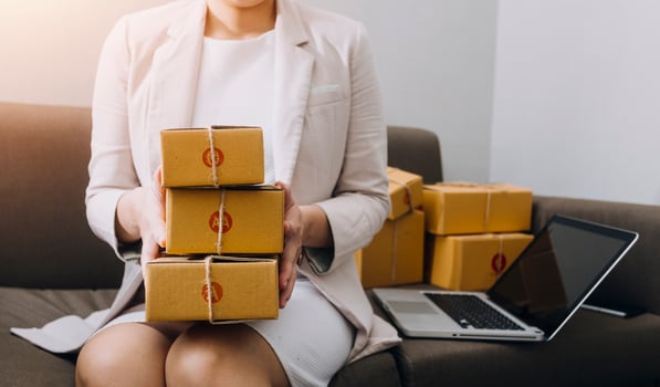 Startup SME small business entrepreneur of freelance Asian woman using a laptop with box Cheerful success Asian woman her hand lifts up online marketing packaging box and delivery SME idea concept photo